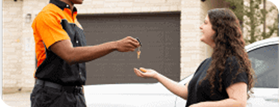 Locksmith handing car keys to customer outside home